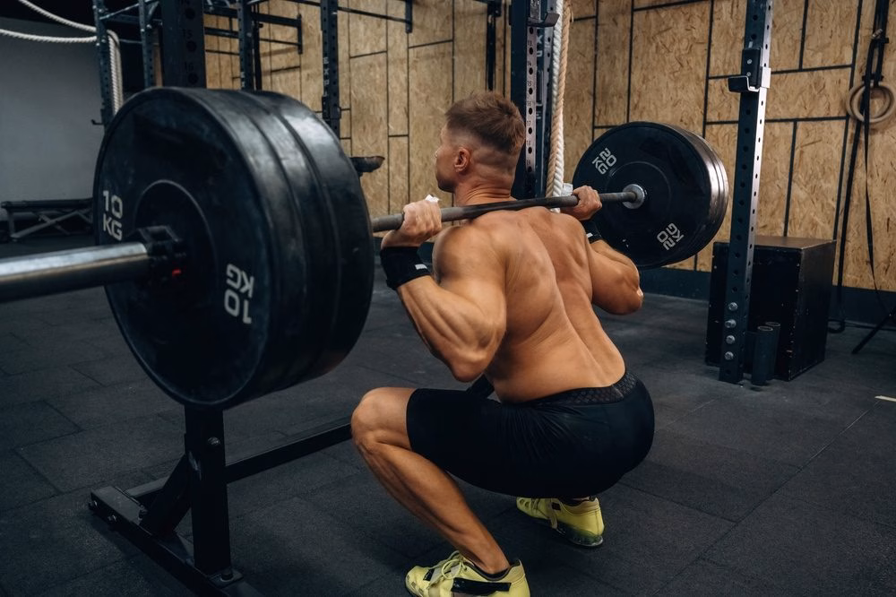 man squatting with weight