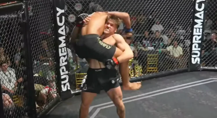 Cole "Wavy" Johnson lifting his opponent off the canvas in a Supremacy MMA cage