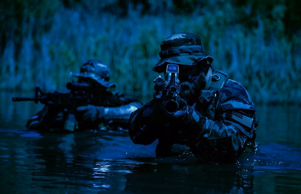 Special operations personnel move through water at night during training