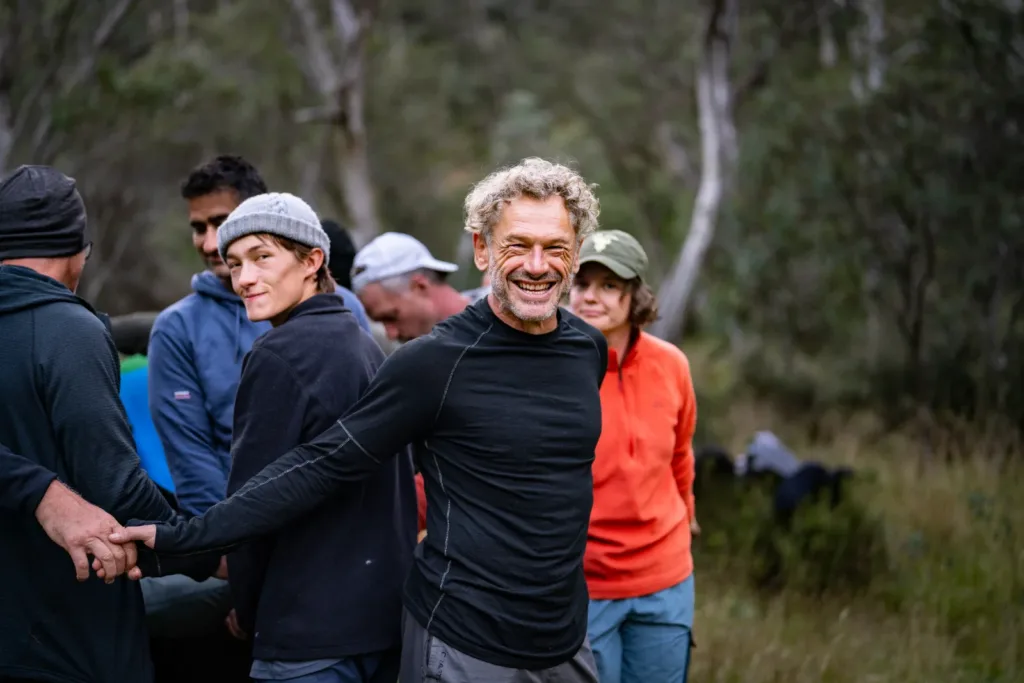 A line of hikers walking together through bushland on a HIGHLANDER Adventure trail