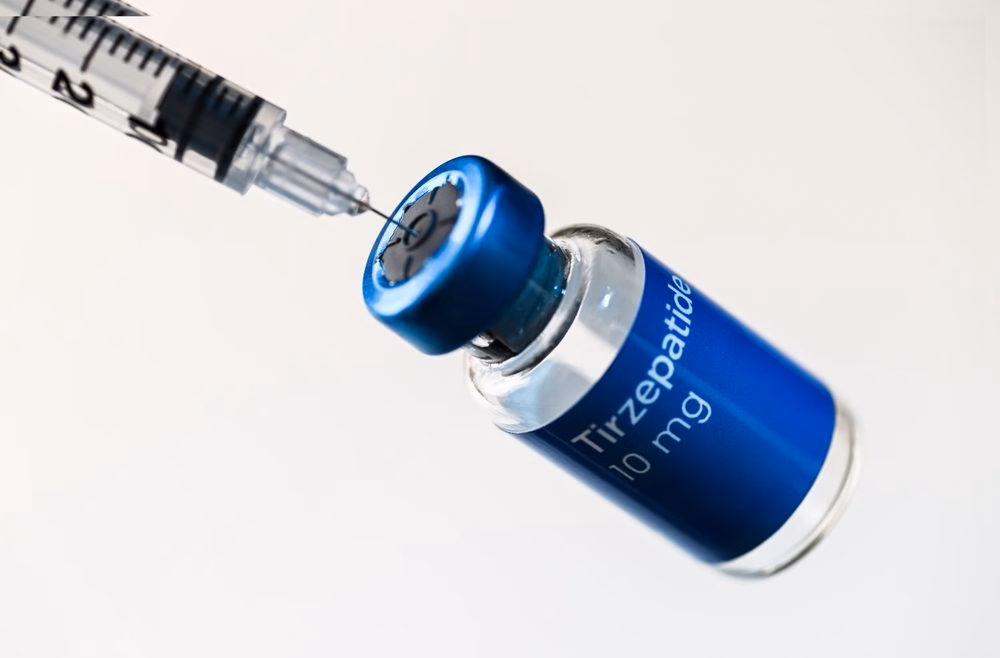 Insulin-style syringe drawing liquid from a small glass peptide vial