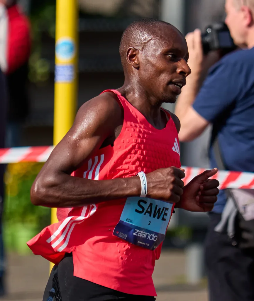 Sabastian Sawe running in a red vest and race bib at the 2025 Berlin Marathon