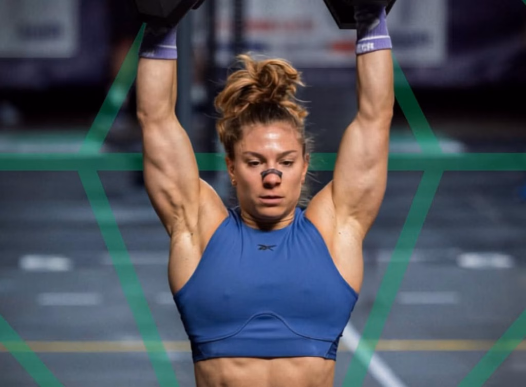 Elisa Fuliano holding dumbbells overhead during a workout