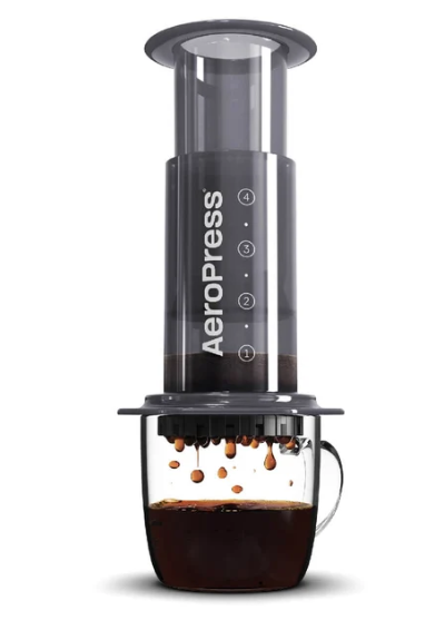 AeroPress coffee maker pressing coffee into a glass mug