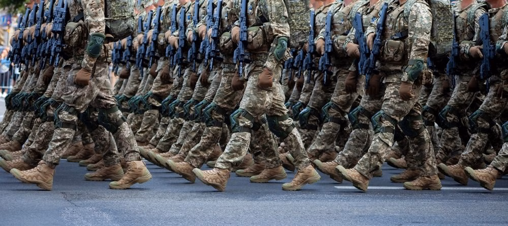 Rows of soldiers in desert camouflage marching in formation